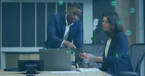 Business professionals collaborating with digital technology in modern office