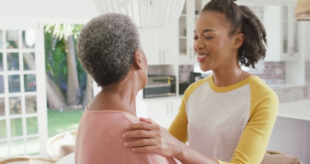 Young woman engaging with elderly family member in bright indoor space. Suitable for themes of family connection, elderly care, intergenerational relationships, love and support, home togetherness. Perfect for websites, advertisements, and educational materials about family bonding and caregiving.