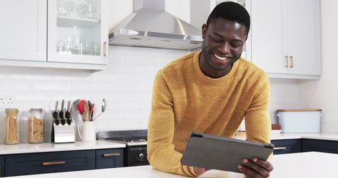 Man in Modern Kitchen Browsing Recipes on Tablet