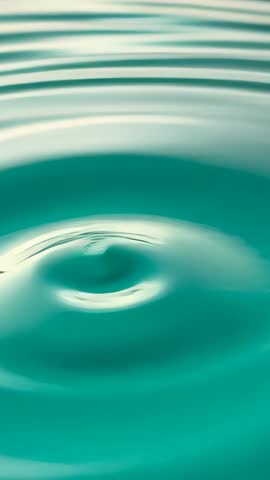 Droplet Hitting Turquoise Water Creating Expanding Ripples | Vertical Slow Motion Loop