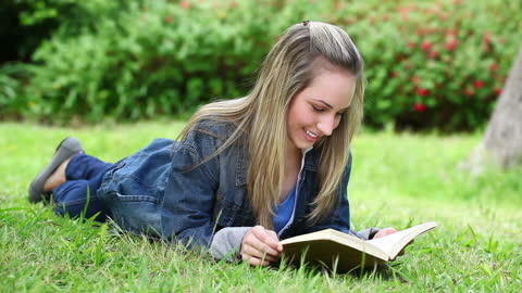 Woman Reading a Book in Park with Greenery