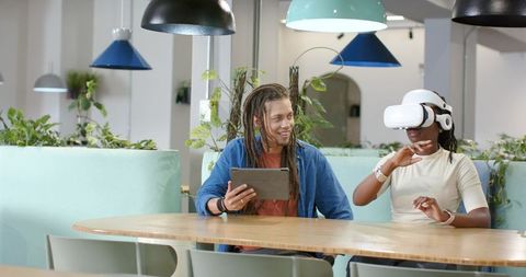 African american coworkers testing vr headset and tablet in modern coworking space