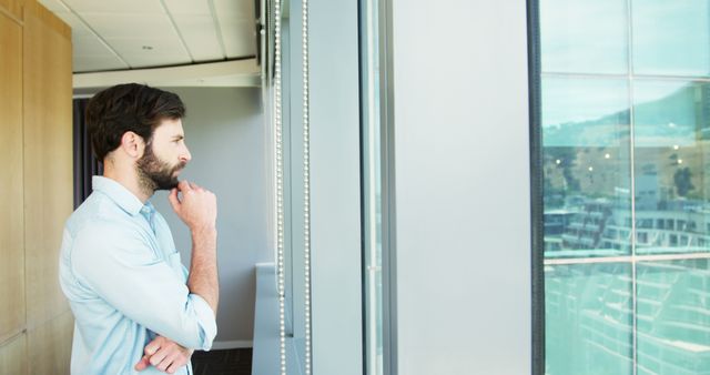 Contemplative Man Looking Out Window in Modern Office Space - Download Free Stock Images Pikwizard.com