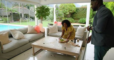 Couple Tidying Up After Party in Modern Home Interior