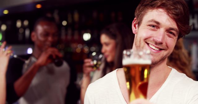 Smiling Man Enjoying Night Out with Friends at Lively Bar - Download Free Stock Images Pikwizard.com