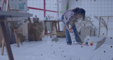 Creative hispanic artist painting floor canvas in art studio