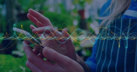 Hands holding smartphone in garden with waveform overlay representing mobile data and audio