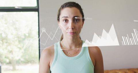 Businesswoman looking at transparent digital financial data visualizations. Conceptualizes integration of finance and technology, representing digital transformations in business. Use for articles about financial data analysis, business intelligence solutions, or modern financial tools.