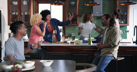 Diverse Friends Celebrating with Wine and Beer in Home Kitchen