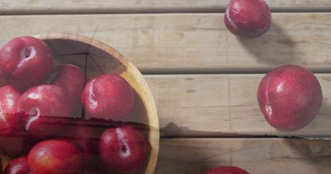 Fresh Red Plums in Wooden Bowl on Rustic Wooden Table