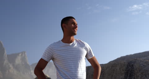 Confident Young Man Enjoying Day on Rocky Beach