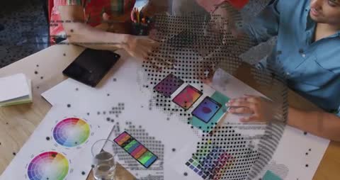 Design team collaborating over color palettes and mobile mockups with dotted globe overlay