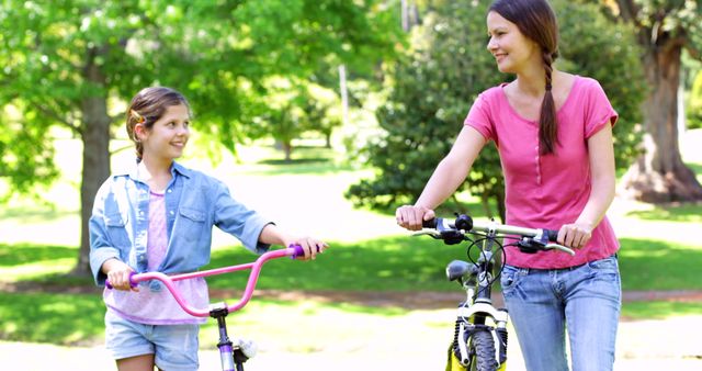 Mother and Daughter Riding Bicycles in Park on Sunny Day - Download Free Stock Images Pikwizard.com