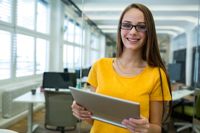 Portrait of female business executive holding digital tablet in office