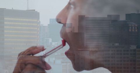 Elegant senior african american woman applying lipstick in city