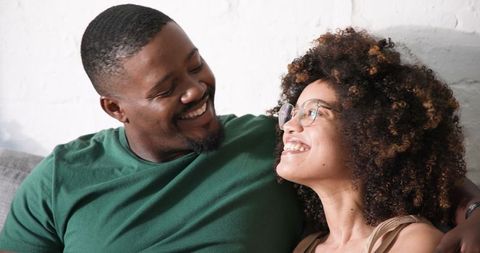 Loving Couple Smiling on Cozy Sofa at Home