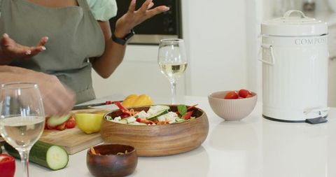 Women Preparing Vegetable Salad in Modern Kitchen with Composting