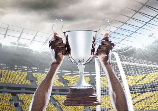 An athlete's hands are holding a trophy high in a bustling stadium filled with spectators. This can be used to represent topics like sports success, personal achievement, winning moments, or motivational themes.