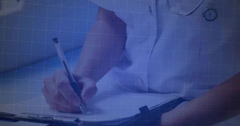 Doctor writing notes at clinic desk with stethoscope