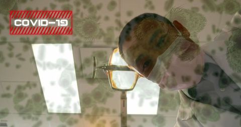 Doctor examining patient amidst covid-19 virus overlay in hospital setting