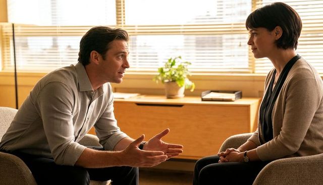Man and woman engaging in confidential workplace counseling conversation in bright office
