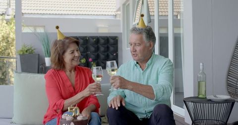 Senior Couple Celebrating Birthday with Wine and Cake on Sunny Patio