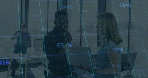 Collaborating team exchanging laptop over digital data grid overlay for analytics presentation