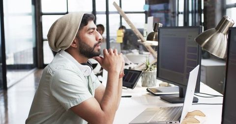 Focused young professional reflecting at modern desk