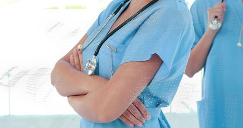 Nurse Crossing Arms with Stethoscope Showing Confidence and Teamwork in Hospital Corridor