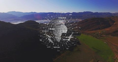 Futuristic holographic globe with radial grid overlaying aerial mountain valley and fields