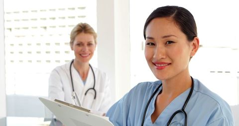Confident Surgeon Holding Clipboard with Nurse in Hospital - Download Free Stock Images Pikwizard.com
