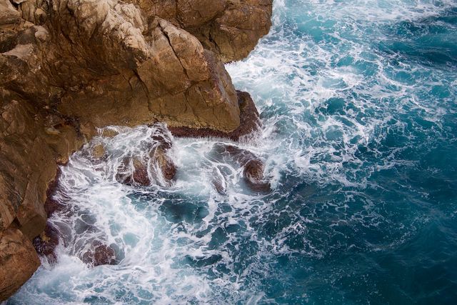 Rocky coastline with crashing waves creating sea spray - Download Free Stock Photos Pikwizard.com