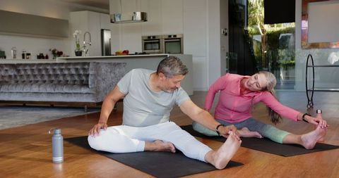 Active Couple Practicing Yoga Stretches at Home