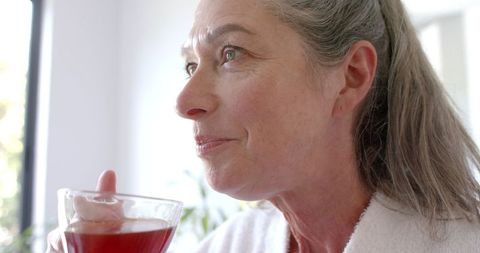 Mature woman enjoying tea in tranquil home interior