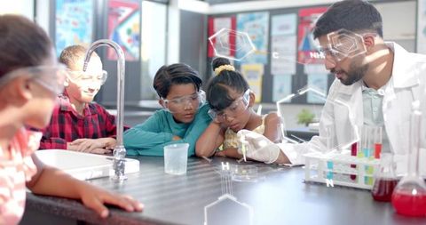 Instructor demonstrating pipette experiment with curious students in bright school lab