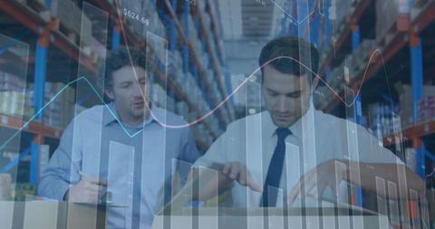 Caucasian Male Workers Analyzing Warehouse Logistics with Financial Graphs