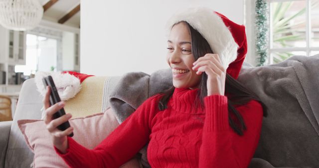 Biracial woman with santa hat having image call. Beauty, health and female spa home concept.