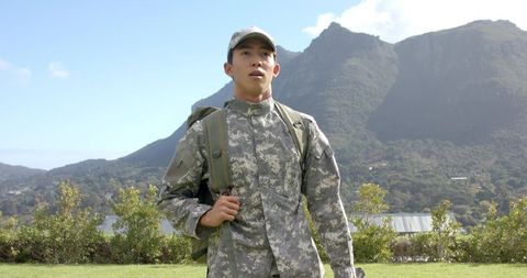 Asian male soldier ready for mission in scenic mountains