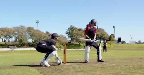 Diverse cricket players at crease in tense stand-off