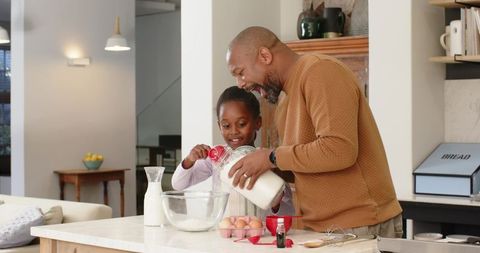 Father and Daughter Enjoying Baking Together in Modern Kitchen