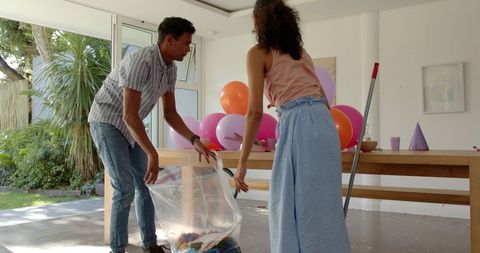 Couple preparing festive decorations with balloons and confetti