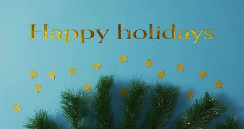 Gold happy holidays lettering featuring pine sprigs, glitter stars on bright blue backdrop