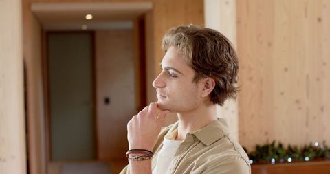 Thoughtful Young Man Relaxing in Cozy Rustic Lounge