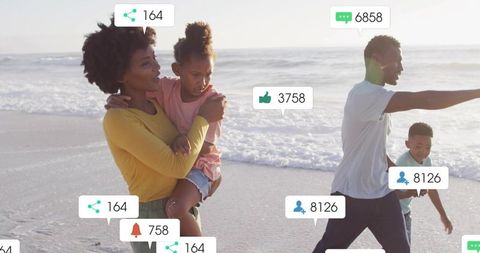 Family walking on beach carrying child with social media engagement icons floating