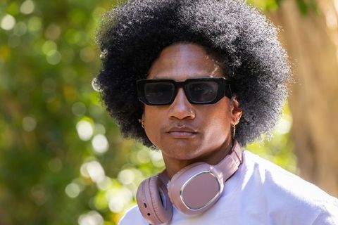 African american man wearing black sunglasses and pink headphones, outdoor portrait