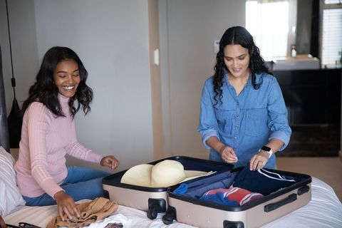 Diverse women packing suitcase for leisure travel