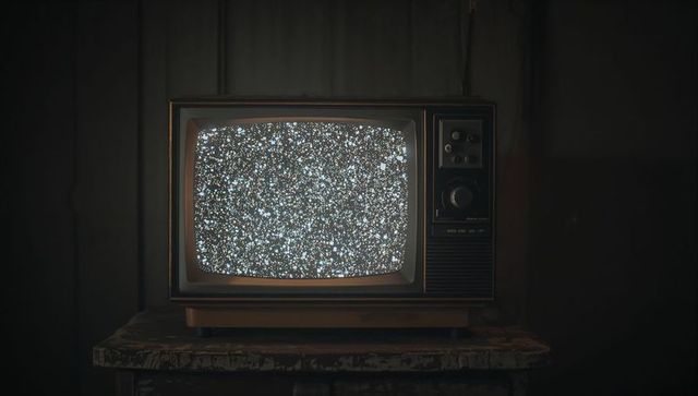 Vintage CRT Television Displaying Static Noise in Dim Room