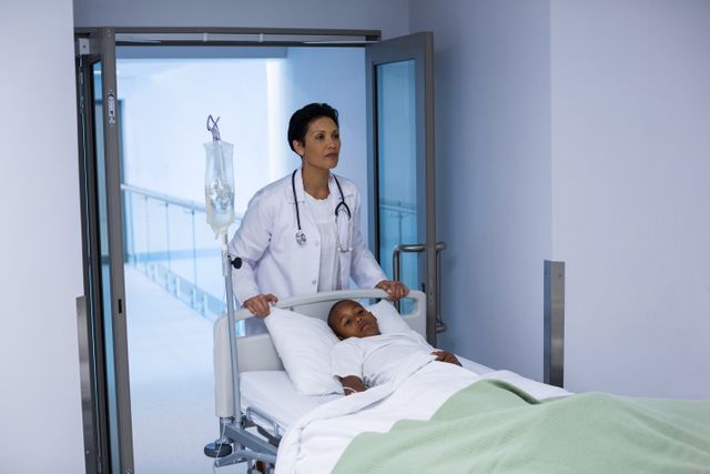 Doctor pushing emergency stretcher bed with patient in hospital corridor. Ideal for use in healthcare, medical, and emergency response contexts. Useful for illustrating hospital environments, patient care, and medical staff in action.