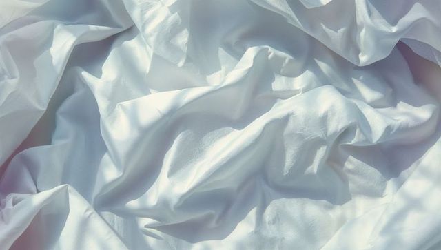 Creased white fabric with soft lighting and gentle textures