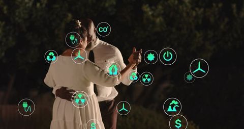 Mature couple dancing in garden at night with green energy and sustainability icon overlay